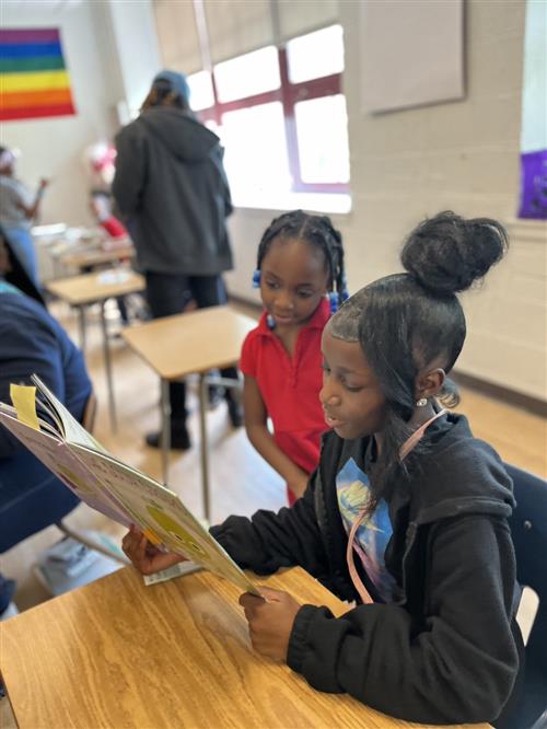 7th grade scholar reading to a 1st grade scholar